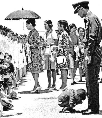 An Iconic Moment: A young boy, Phayung Sak, bows in reverence to King Rama 9 during a historic royal visit, symbolizing the deep respect and admiration for the beloved monarch.